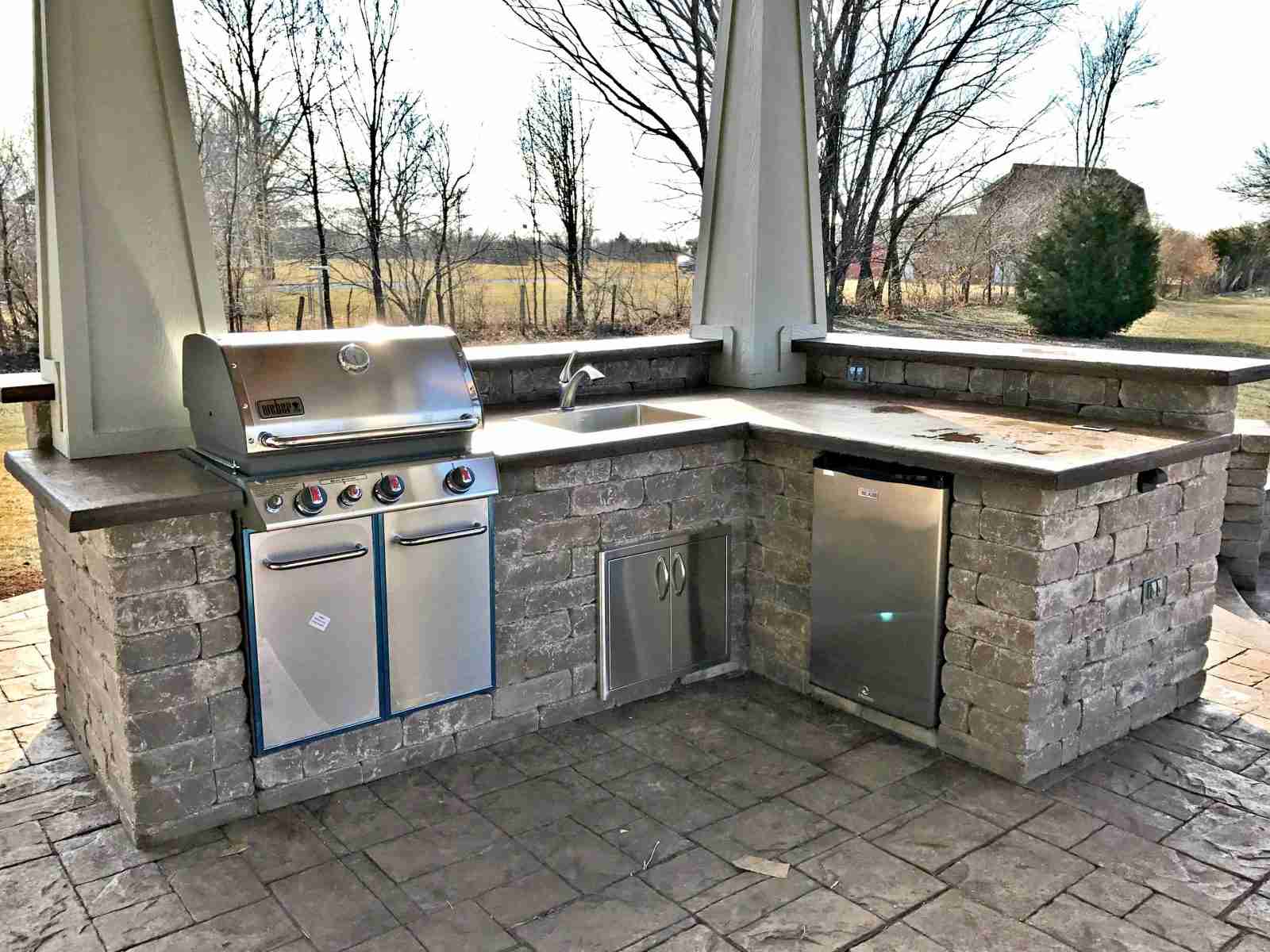stunning covered structure, grill station, and fire pit area
