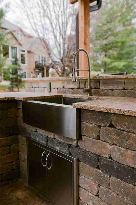 granite counters, stainless steel storage, a farmhouse sink