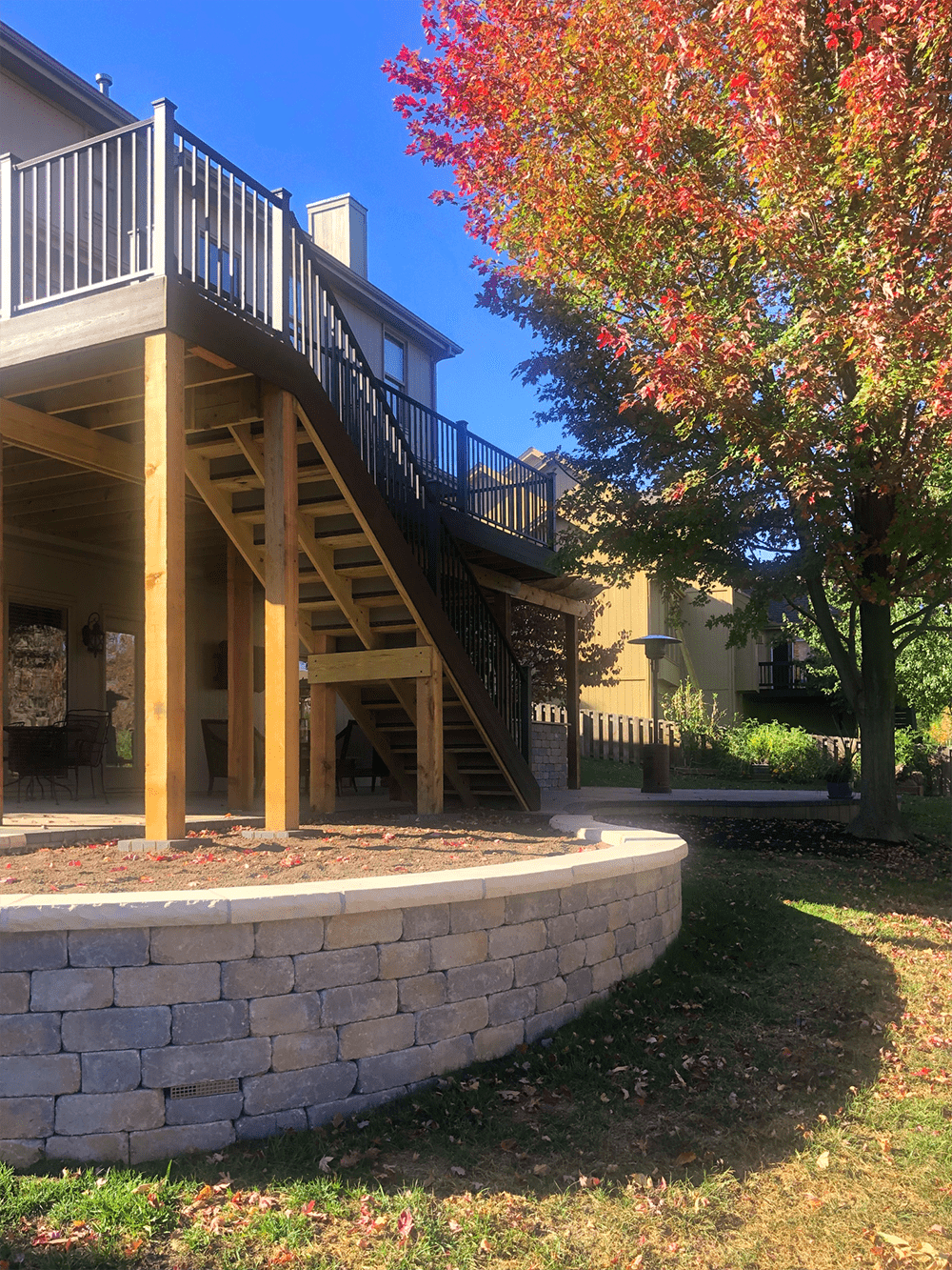 Elevated outdoor double-decker deck featuring a covered lower patio and upper lounging area