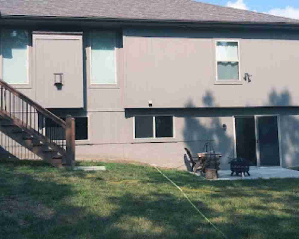 Custom patio and outdoor living space with comfortable seating in a landscaped backyard